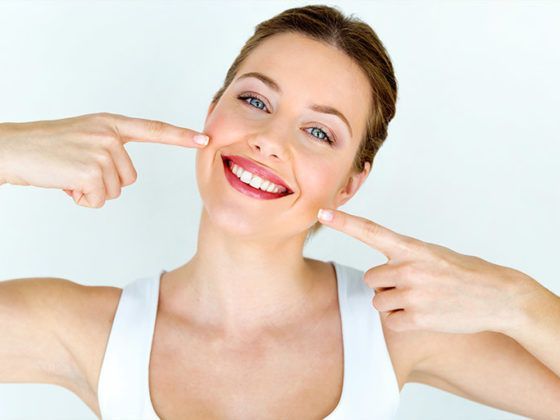 Clínica dentral Beatriz Vega. Chica feliz por haber evitado la periimplantitis en sus implantes dentales