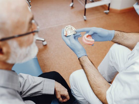 Señor mayor dudando entre implantes o dentadura. Dentista en Gijón